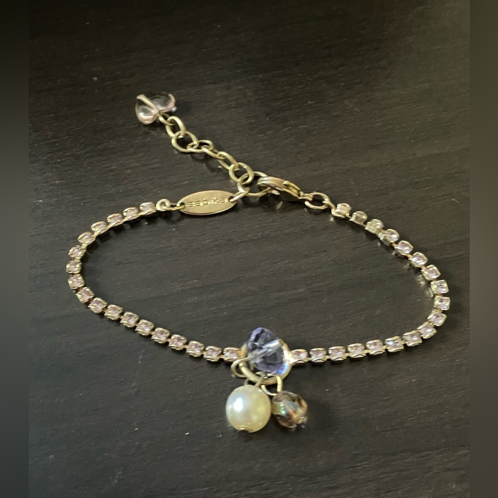 Vintage gold tone Sabika bracelet with pale pinkish purple rhinestones.
